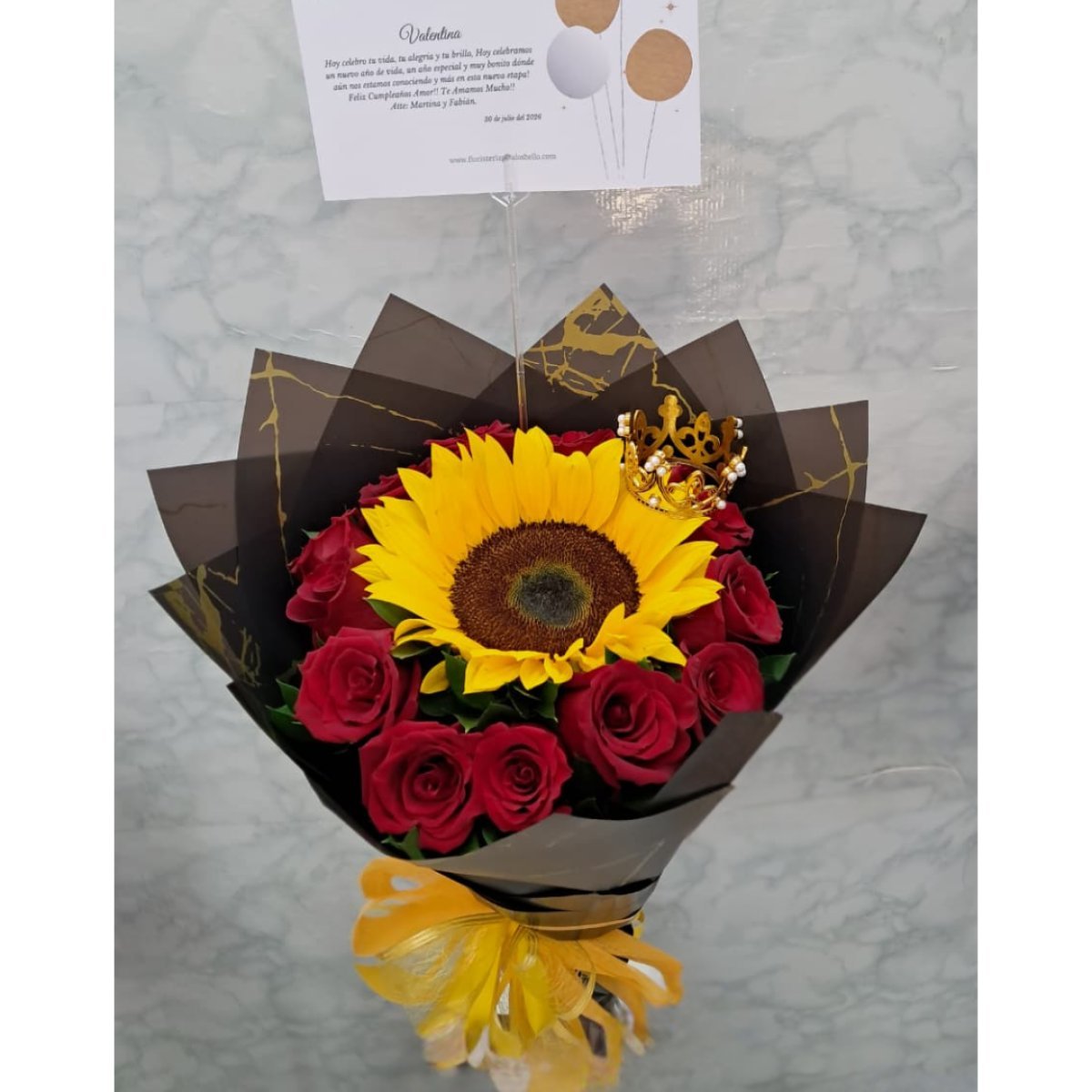 Bouquet de rosas y girasol con corona decorativa.