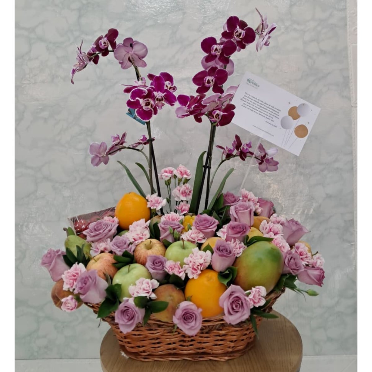 Canasta de frutas con orquídea y flores